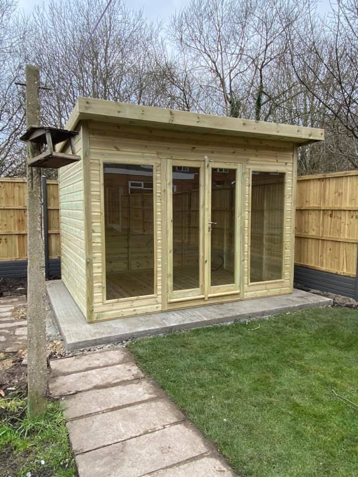 Timber garden room on a slab base beside a new fence and a paved path